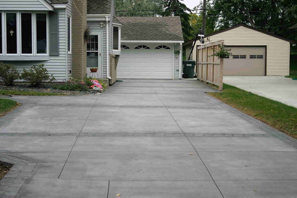 A driveway with concrete and asphalt in it.